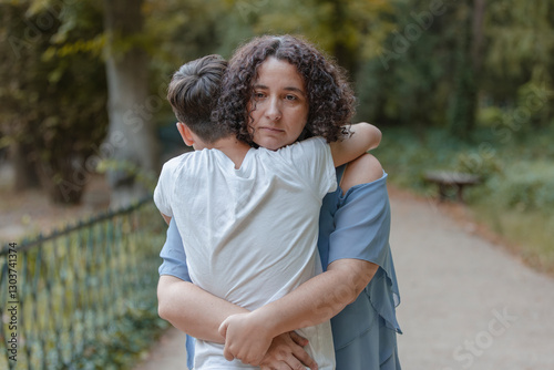 A woman is hugging a young boy