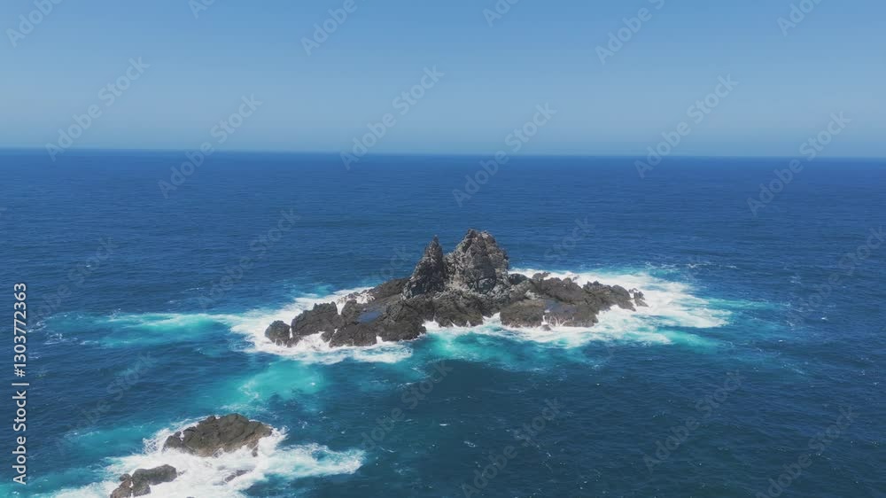 Aerial view of waves crashing against isolated rock island in Lombok