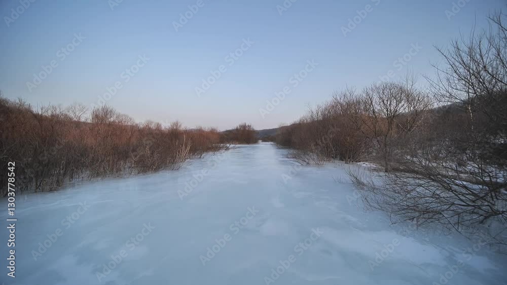 Frozen river and tree branches coated in ice during a serene winter, evoking stillness and chill, northeast China. Frozen river and tree branches coated in ice during a serene winter, evoking stillness and chill, northeast China.