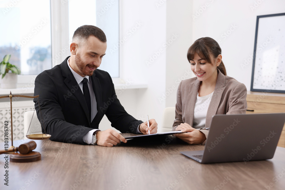 Client signing notarial paperwork during meeting with lawyer at wooden desk indoors Client signing notarial paperwork during meeting with lawyer at wooden desk indoors