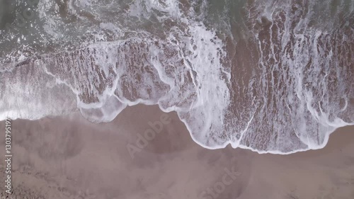 Vista aérea del mar con olas llegando, día soleado, cielo azul y agua cristalina desde un dron