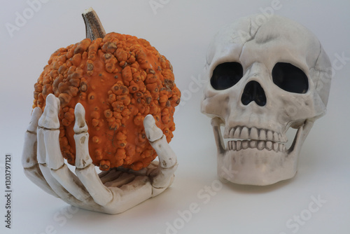 Skull and hand with warty pumpkin
