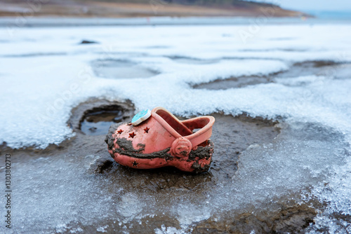 Lost plastic shoe found at the bottom of a waterless lake in winter
