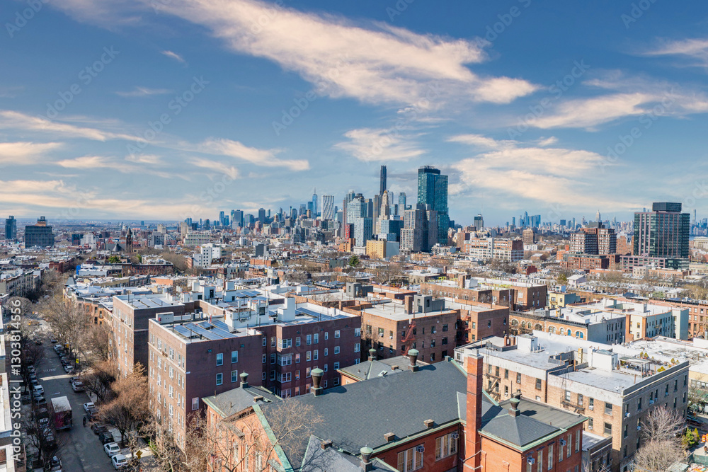 Naklejka premium A breathtaking view of Brooklyn showcasing its diverse architecture, from historic brownstones to contemporary buildings, with the iconic Manhattan skyline rising in the background. The contrast betwe