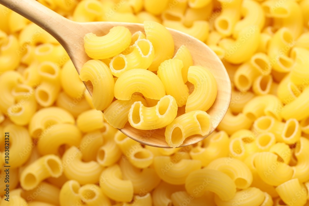 Raw horns pasta and spoon as background, top view Raw horns pasta and spoon as background, top view