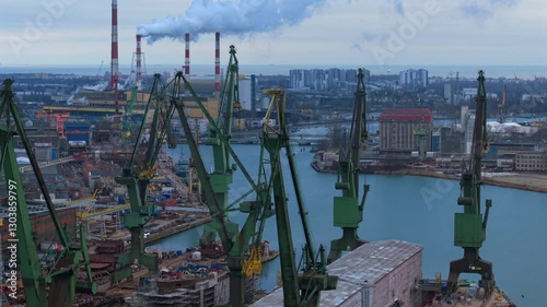 Drone medium orbit, cranes in Gdansk Shipyard with EC 2 coal plant smokestacks and football arena in the distance