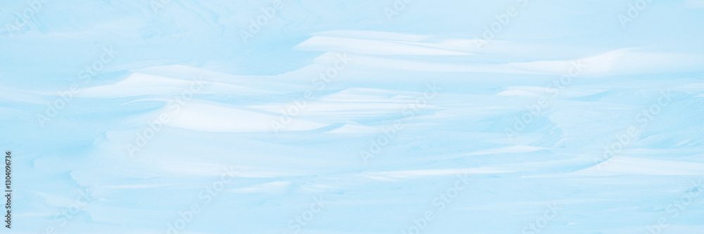Fototapeta premium Wide panoramic winter background with snowy ground. Natural snow texture. Wind sculpted patterns on snow surface. Arctic, Polar region.