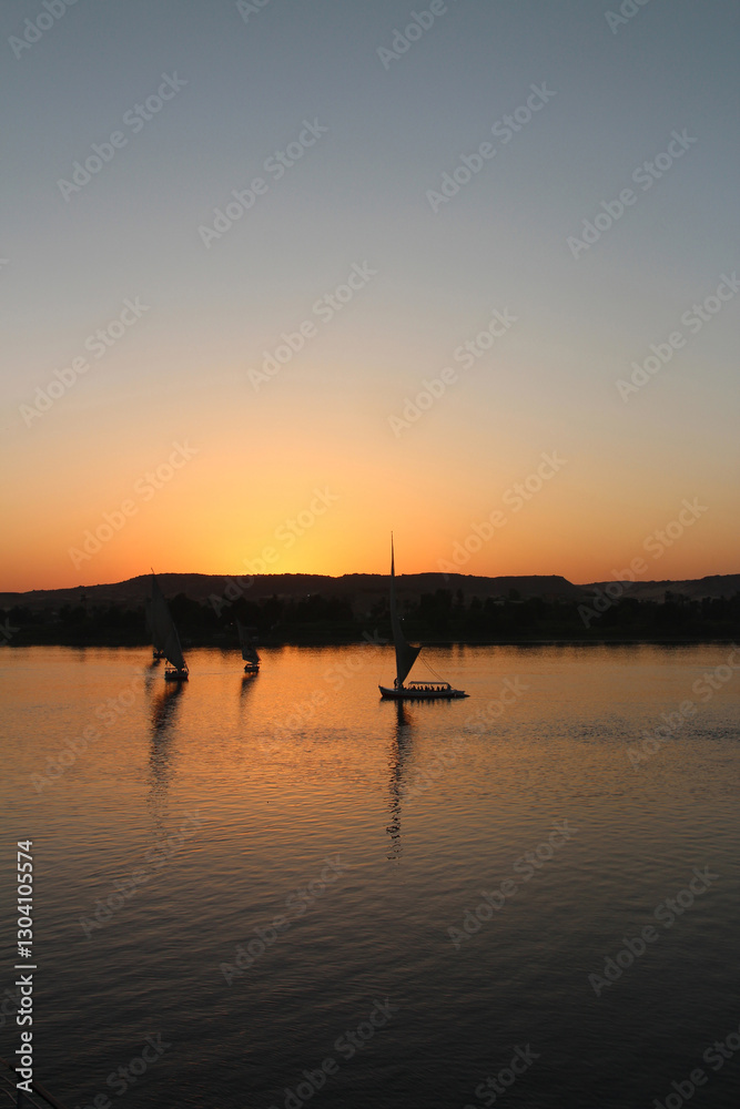 Felucca sailing on Nile River during sunset at Aswan, Egypt