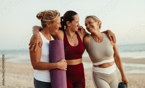 Three women enjoying yoga and friendship by the beach at sunset