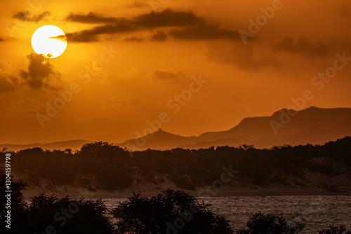 A golden sunset looking across the water on a hot and humid day in Cooktown, Far North Queensland, Australia.	