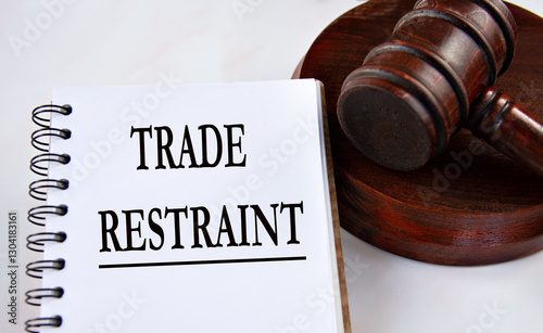 TRADE RESTRAINT - words in a white notebook with a judge's gavel in the background