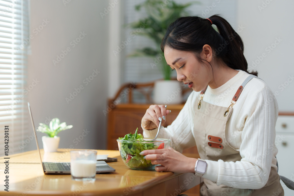 Young woman eating healthy salad while working from home office Young woman eating healthy salad while working from home office