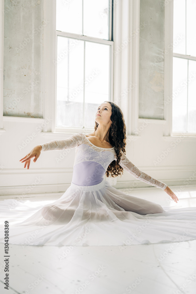Ballerina extending arms in soft natural window light Ballerina extending arms in soft natural window light