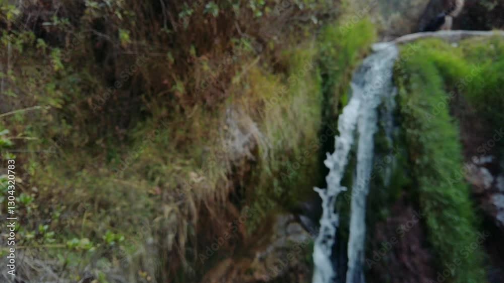 Pan shot of bush and a small cascade during the day in the surrounding mountains of Cusco leading from Puka Pukara ruins to Inkilltambo and Rumiwasi ruins Pan shot of bush and a small cascade during the day in the surrounding mountains of Cusco leading from Puka Pukara ruins to Inkilltambo and Rumiwasi ruins