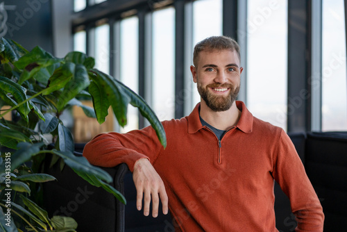 Portrait of a smiling young man in a modern office setting