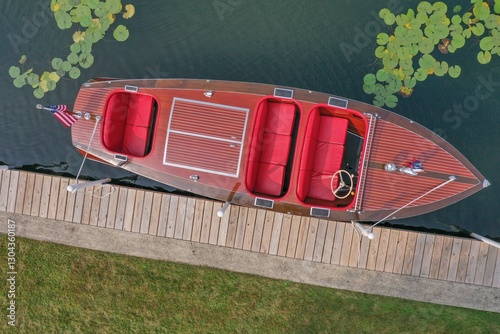 Aerial view of a classic wooden boat docked by a pier.