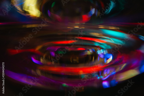 Abstract multicolour background. New Year lights. Blurred colourful light on champagne glass. Rainbow flash in dark. Futuristic shiny background. Illuminated effect. Bright glowing.