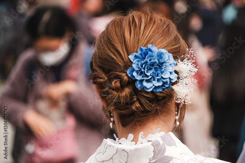 Woman dressed in traditional kimono with an elegant braided hairstyle adorned with blue flower accessory, captured at Sensoji Temple, Tokyo, Japan. Cultural and historical travel experience in Asakusa photo