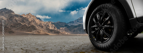 A black tire is on a rocky road in front of a mountain