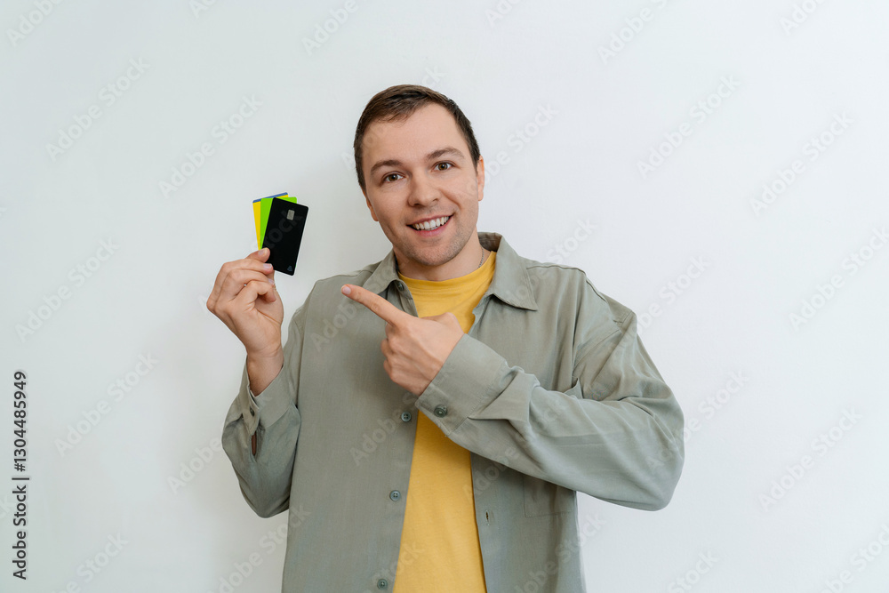 Portrait of attractive cheerful guy holding in hand demonstrating bank card deposit Portrait of attractive cheerful guy holding in hand demonstrating bank card deposit
