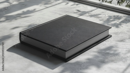 A sleek hard cover book mockup, bathed in the soft glow of a grey backdrop, ready to showcase its cover design and captivating content to the world.