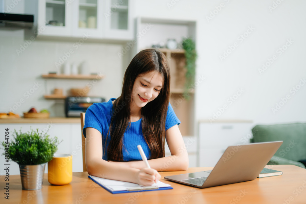 Happy woman with headphones working on a tablet in a bright kitchen. Ideal for themes of remote work Happy woman with headphones working on a tablet in a bright kitchen. Ideal for themes of remote work