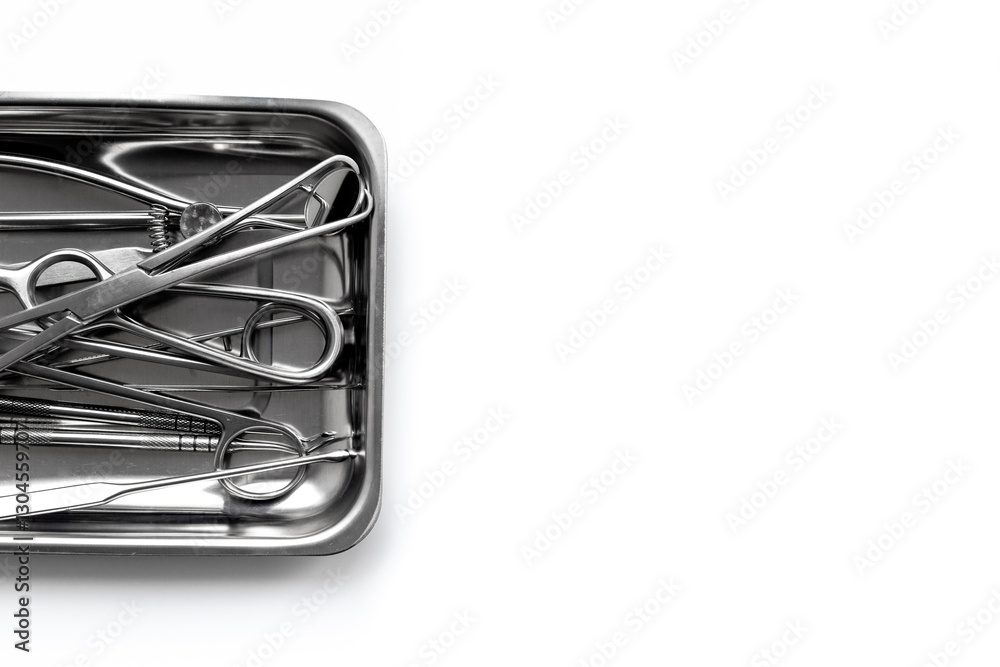 Surgical professional stainless metal instruments in tray on white background, top view. Medical equipment Surgical professional stainless metal instruments in tray on white background, top view. Medical equipment