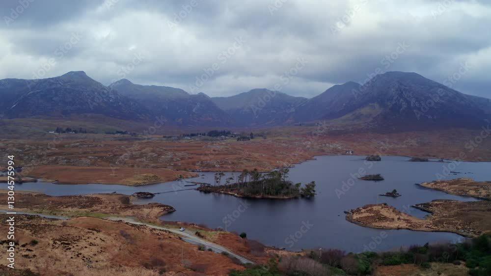 Aerial tracking shot of Pine Island and the Twelve Bens at twilight, showcasing Connemara’s dramatic beauty, Galway, Ireland Aerial tracking shot of Pine Island and the Twelve Bens at twilight, showcasing Connemara’s dramatic beauty, Galway, Ireland