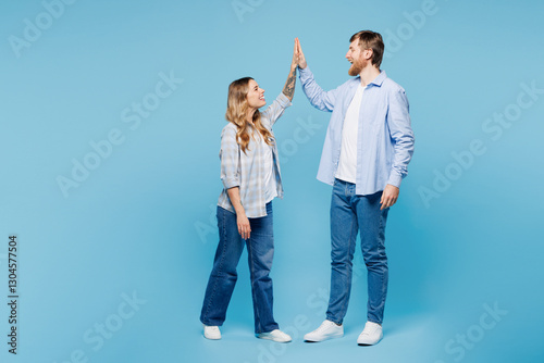 Full body young fun couple two friends family man woman wear shirt casual clothes meeting together greeting giving high five clapping hands folded isolated on plain blue background. Lifestyle concept.