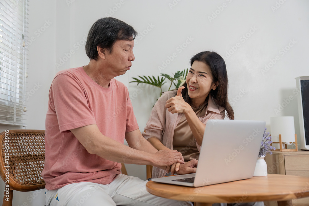 Senior couple sharing a playful moment while using a laptop at home. Senior couple sharing a playful moment while using a laptop at home.