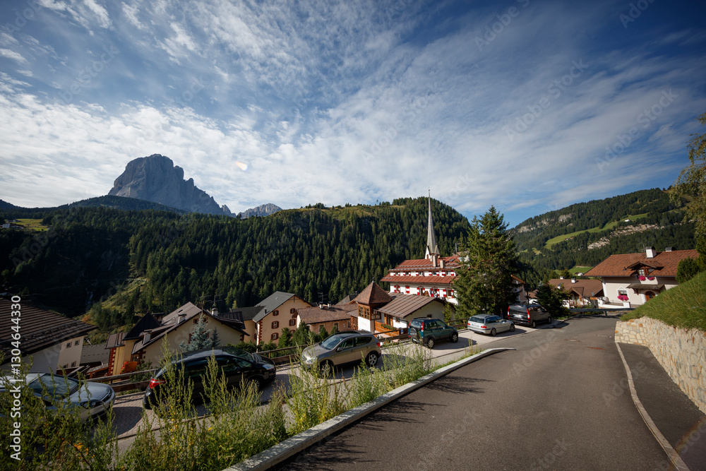 Naklejka premium Relaxing village atmosphere in the Dolomites with stunning mountain backdrop and clear skies