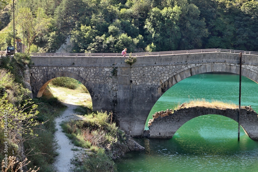 Villalago - Turista sul ponte del Lago di San Domenico
