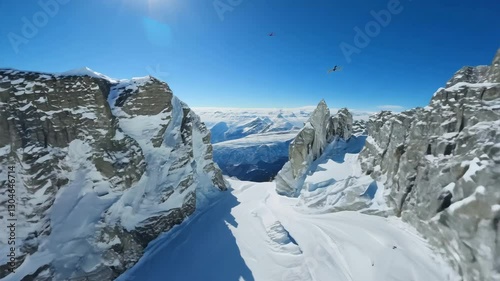 Aerial view flying over picturesque mountain ridge snowy rock texture sun light blue sky landscape. FPV sports drone empty alpine scenery winter glacier freeze valley natural cliff range freeze summit