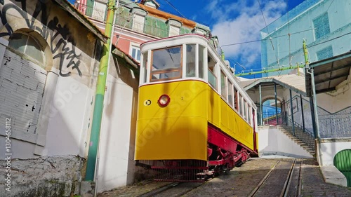 Lisbon, Portugal, 26 February 2025: The old yellow tram, funicular on the narrow street in Lisbon