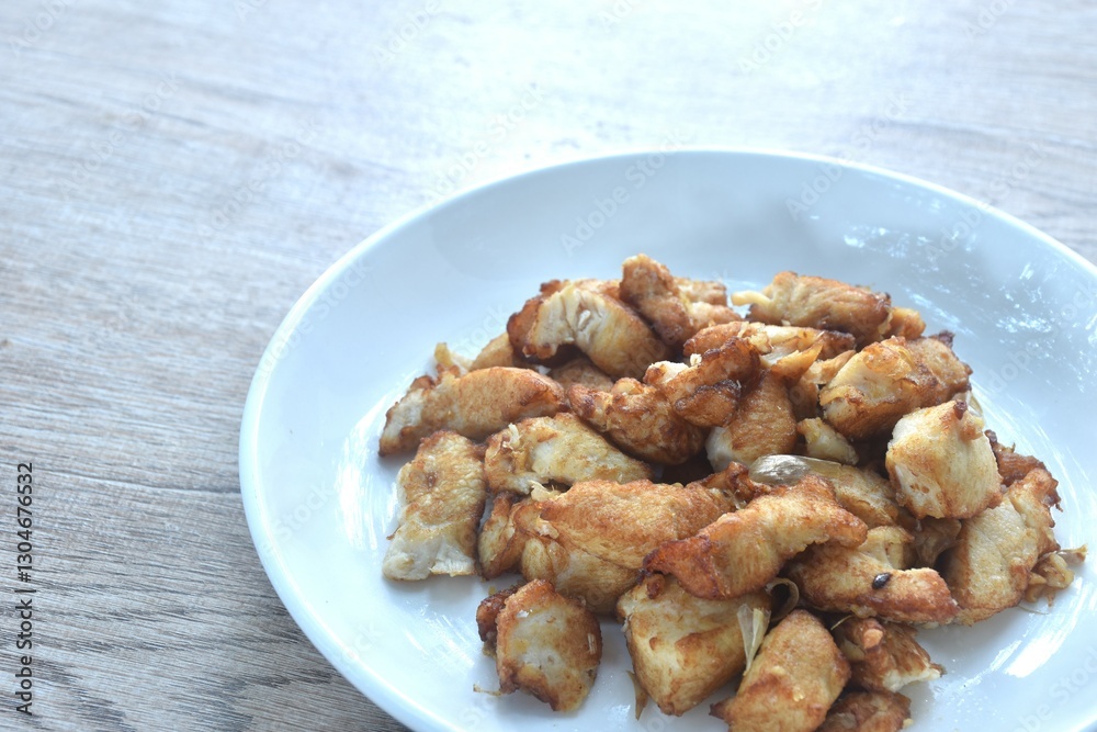 fried slice chicken meat with salt and garlic on plate