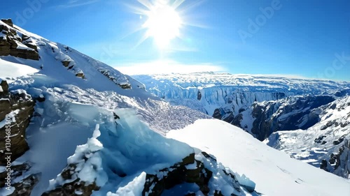 Aerial view flying over picturesque mountain ridge snowy rock texture sun light blue sky landscape. FPV sports drone empty alpine scenery winter glacier freeze valley natural cliff range freeze summit
