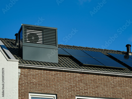 Modern row house rooftop with HVAC unit and solar panels in Assen, Netherlands, showcasing architecture and sustainability