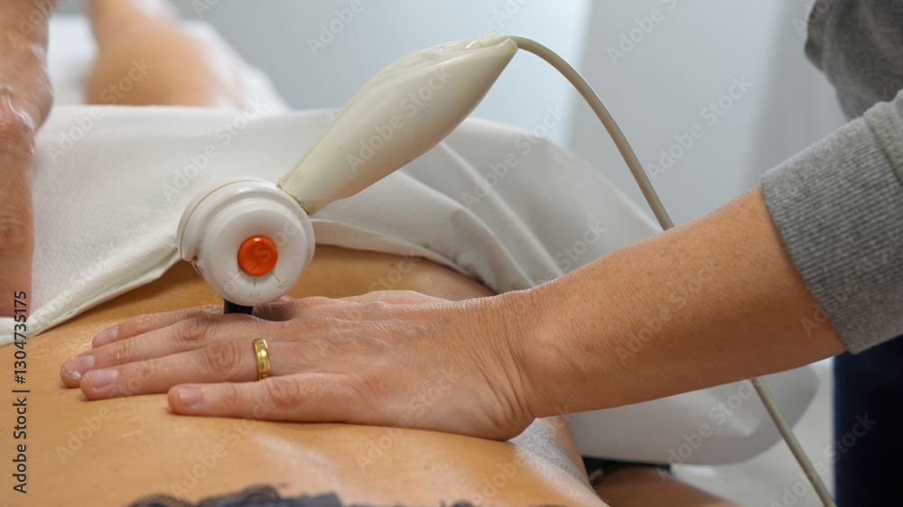 Close-up of TECAR treatment applied to a woman’s shoulder during physiotherapy session