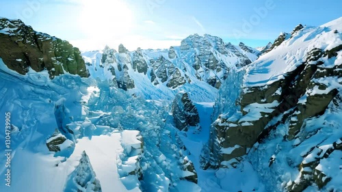 Aerial view flying over picturesque mountain ridge snowy rock texture sun light blue sky landscape. FPV sports drone empty alpine scenery winter glacier freeze valley natural cliff range freeze summit