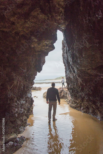 A man walks through a cave on the beach photo
