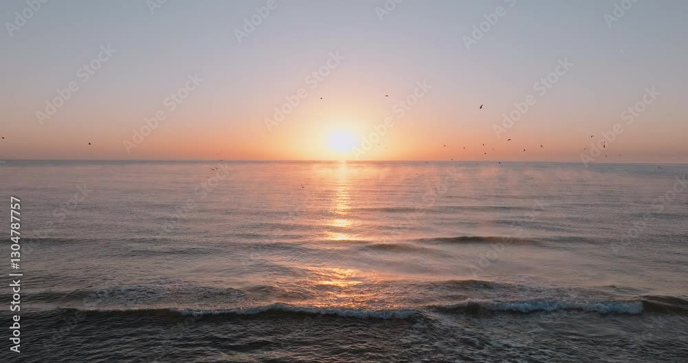 Ocean horizon glows as sun slowly rises, spreading soft pink and orange hues across sky. Gentle waves ripple in rhythmic motion, reflecting peaceful morning light over endless sea. Ocean horizon glows as sun slowly rises, spreading soft pink and orange hues across sky. Gentle waves ripple in rhythmic motion, reflecting peaceful morning light over endless sea.