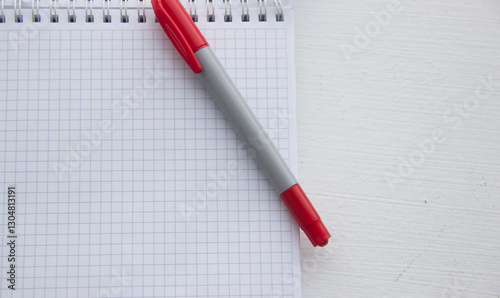 Obraz na plátně Checkered notebook with red marker