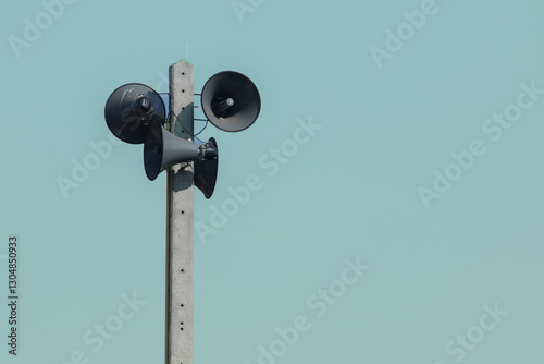 Vintage style amplifier installed on the electric pole wirelessly. The speaker receives waves and distributes sound signals for communication and public relations.