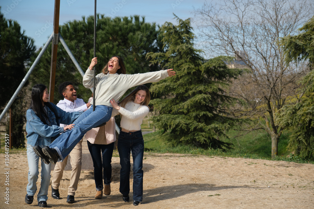 Group of young adults playing together with a zip line in a park during a sunny day