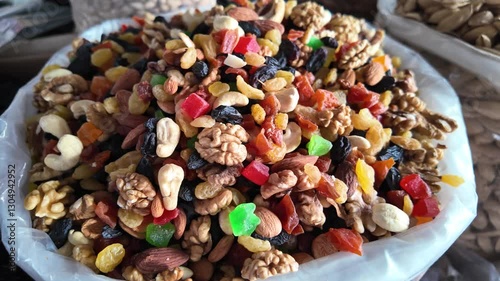 Dried fruits in a bag: walnuts, dried apricots, peanuts, raisins, cashews, almonds, at an open eastern market