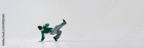 Banner. Street artist striking dynamic one-handed pose with legs airborne, showcasing strength against white background with negative space. Concept of music and dance, urn culture, vintage. Ad