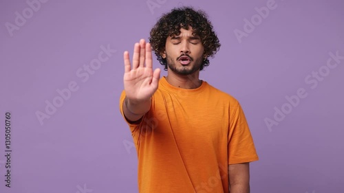 Serious strict severe sad young Indian man wear orange sweater casual clothes say no hold palm folded crossed hands in stop gesture isolated on plain pastel light purple background. Lifestyle concept