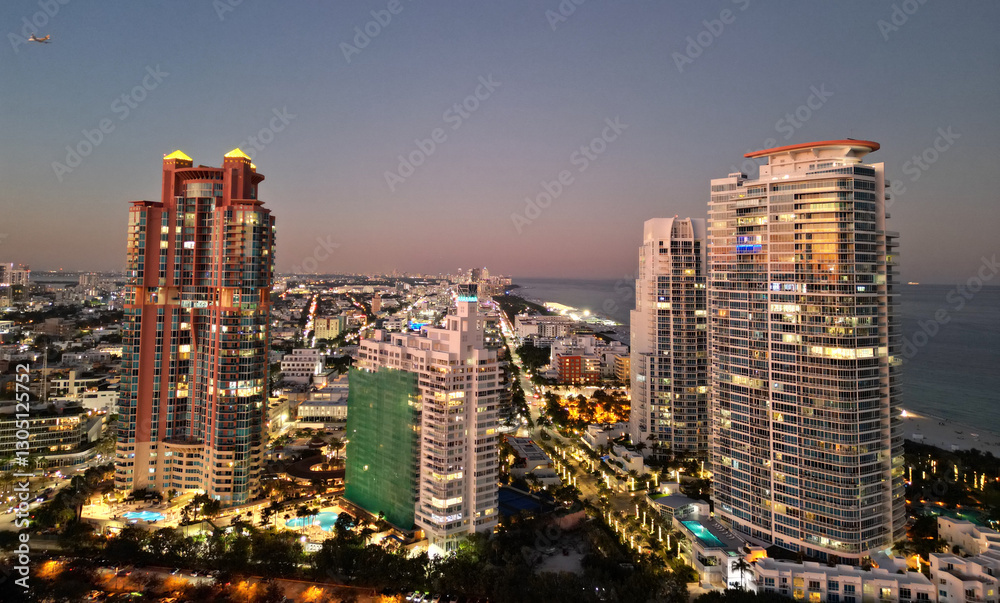 Obraz premium Miami South beach night light. Aerial skyscraper cityscape at night. Night city aerial view. Luxury skyscraper in Miami, Florida. City skyline in evening. Aerial cityscape. Illuminated architecture