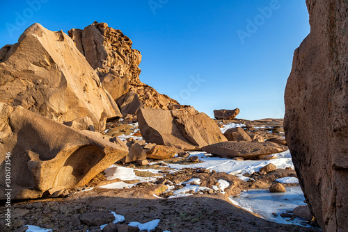 Bektau Ata, Kazakhstan. Spring view with snow and ice on mountains of granite formations with smooth shapes and grooves and geological layers
