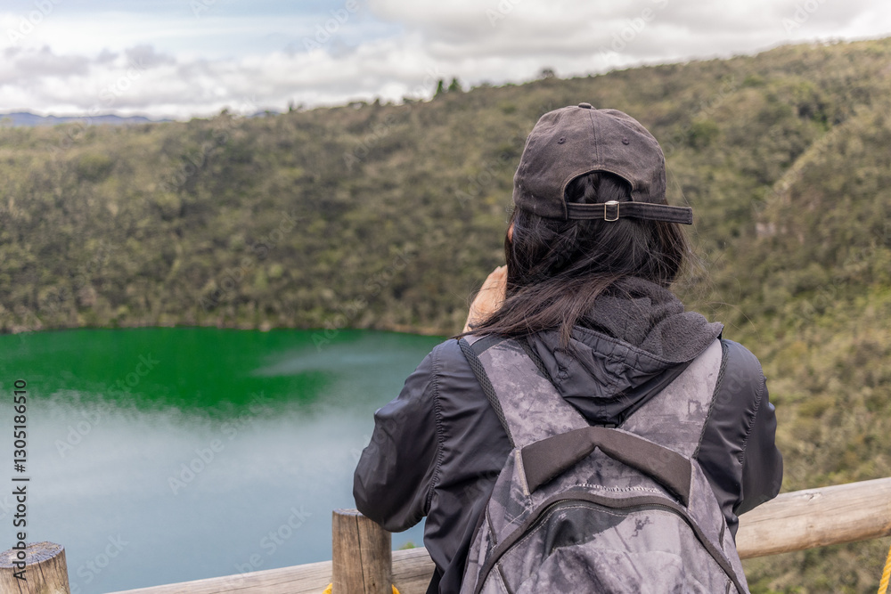 Woman photographer with big backpack taking photo with cellphone of mountains and blue lake. Travel and hobby concept Woman photographer with big backpack taking photo with cellphone of mountains and blue lake. Travel and hobby concept